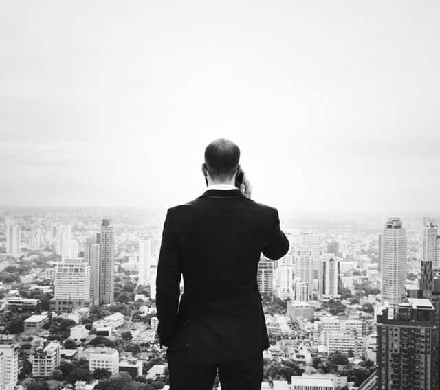 Businessman using a phone looking at the city