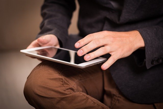 A man using an ipad as one of the tools for selling